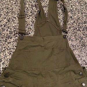 Olive green, skinny distressed overalls.